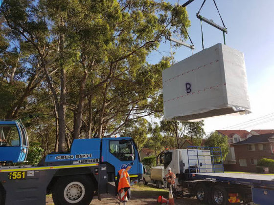 A stack of tough, lightweight MAAP wall panels are delivered to site with a mobile crane